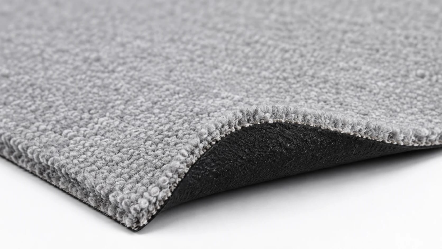 Close-up reference view of low-pile light grey exhibition carpet with black latex backing